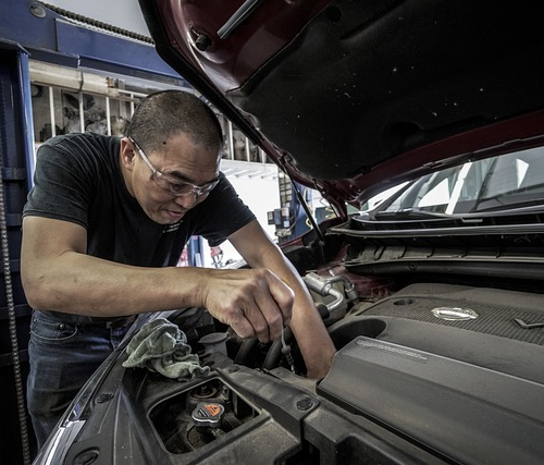 Mechanic repairing car engine.